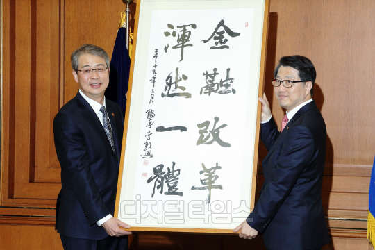 임종룡 금융위원장은 18일 취임 이후 첫 현장방문 행사로 금융감독원을 방문해 진웅섭 금융감독원장 및 주요 임원들과 상견례를 겸한 면담을 했다. 임 위원장은 진웅섭 금융감독원장을 만나 금융개혁을 완수하기 위해서는 유능한 파트너이자 동반자인 금융감독원의 협조가 절실함을 강조하면서 금융개혁 혼연일체라는 액자를 선물했다. 임종룡 위원장(왼쪽)이 진웅섭 원장에게 액자를 전달하며 기념촬영하는 모습.